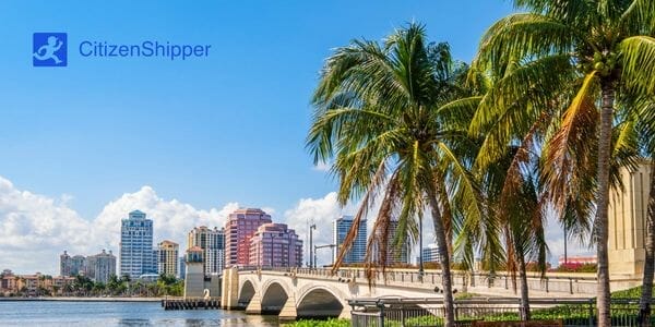 The city of Miami with palm trees and a bridge, offering car shipping from West Palm Beach.