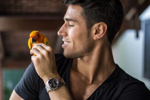 A man is holding a parrot.